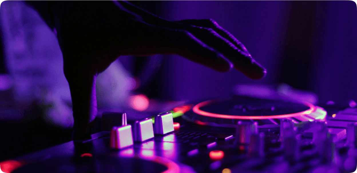 DJ mixing on turntables with purple lighting